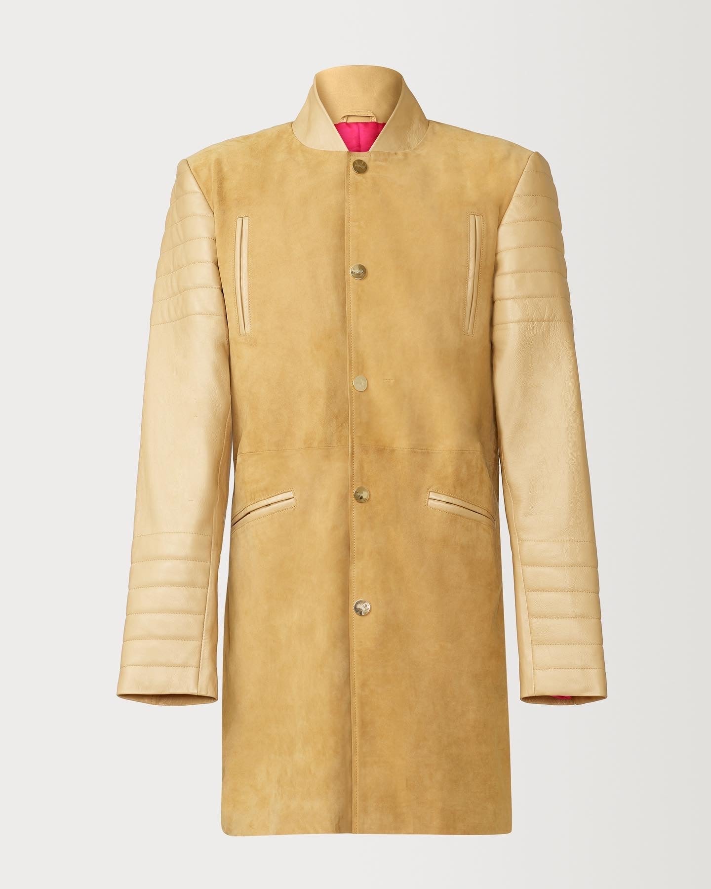 A Beautiful Suede Trench Coat, created by designer brand PRSVR. The PRSVR Lab Coat has a suede Body, and lambskin leather sleeves that show off a padded ribbed design on the shoulder and wrist of the sleeve. 
